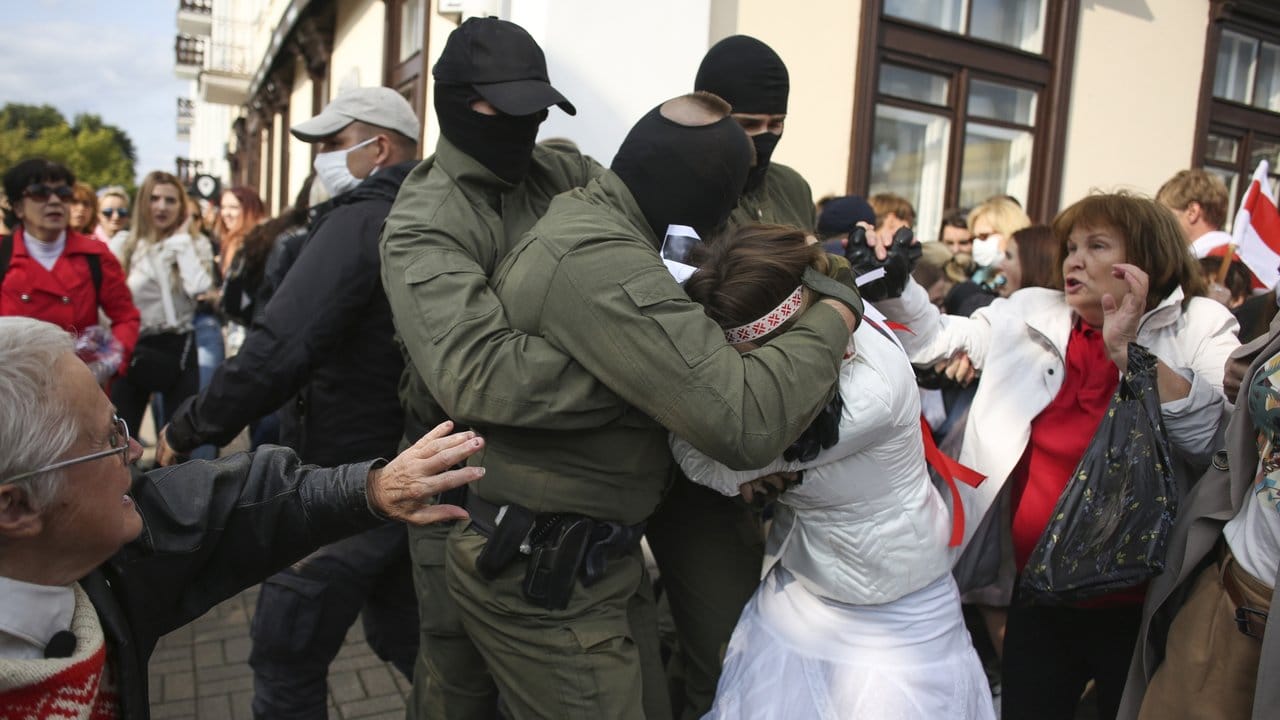 Videos und Fotos zeigen, wie vermummte Sicherheitskräfte in Minsk Frauen hart packen und in Gefangenentransporter zerren.