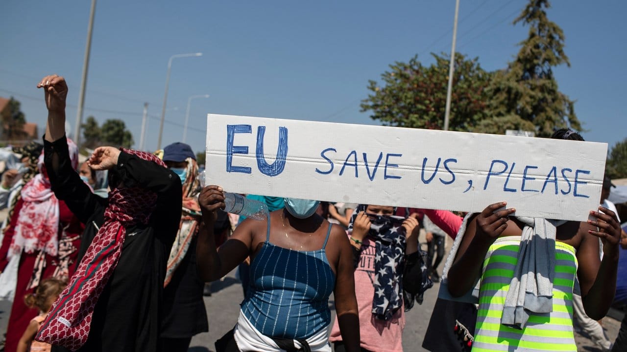 "EU rettet uns, bitte" steht auf einem Schild, das Migrantinnen und Migranten bei einem Protest auf den Straßen von Lesbos tragen.