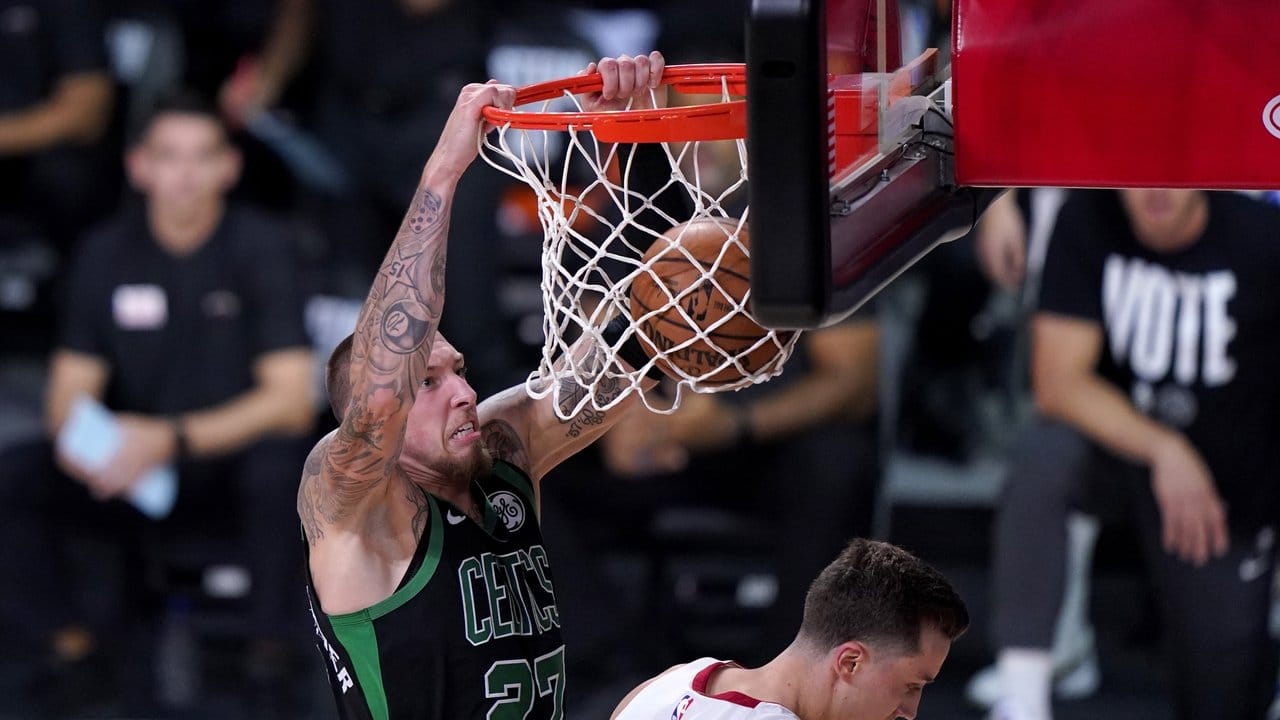 Daniel Theis (l) von den Boston Celtics hängt nach einem Dunking am Korb.