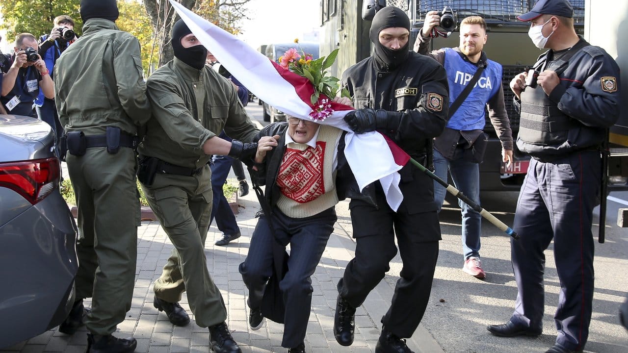 Polizeibeamte versuchen Nina Bahinskaya, eine 73 Jahre alte Frau, am Rande einer Demonstration gegen die Wahlergebnisse in Belarus wegzutragen.