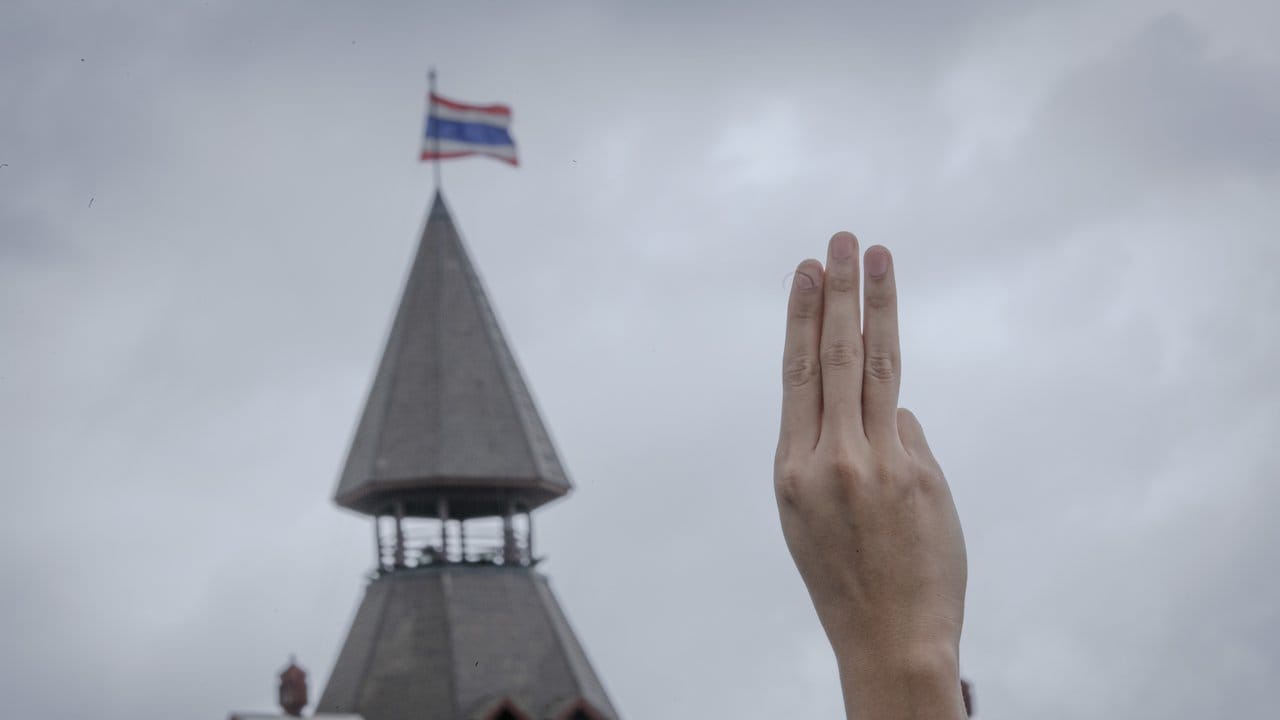 Ein pro-demokratischer Demonstrant erhebt während einer Demonstration im Sanam-Luang-Park drei Finger als Symbol des Widerstands.