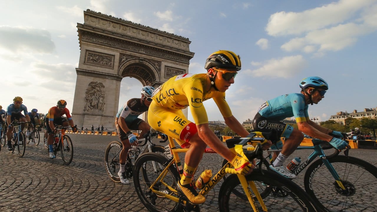 Der Slowene und Gesamtsieger Tadej Pogacar (M), der das gelbe Trikot des Gesamtführenden trägt, fährt am Arc de Triomphe vorbei. Der Slowene und Gesamtsieger Tadej Pogacar (M), der das gelbe Trikot des Gesamtführenden trägt, fährt am Arc de Triomphe vorbei.