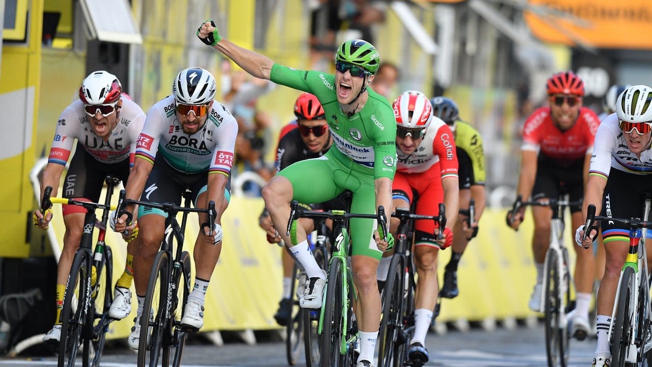 Der Ire Sam Benett (M) vom Team Deceuninck-Quick-Step, der das grüne Trikot des besten Sprinters trägt, bejubelt seinen Etappensieg bei der Zieleinfahrt. Der Ire Sam Benett (M) vom Team Deceuninck-Quick-Step, der das grüne Trikot des besten Sprinters trägt, bejubelt seinen Etappensieg bei der Zieleinfahrt.
