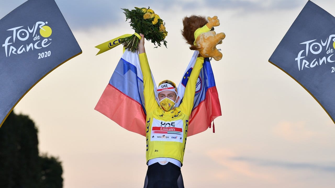 Der Slowene Tadej Pogacar vom UAE Team Emirates feiert im gelben Trikot des Gesamtführenden seinen Sieg bei der Tour de France 2020. Der Slowene Tadej Pogacar vom UAE Team Emirates feiert im gelben Trikot des Gesamtführenden seinen Sieg bei der Tour de France 2020.