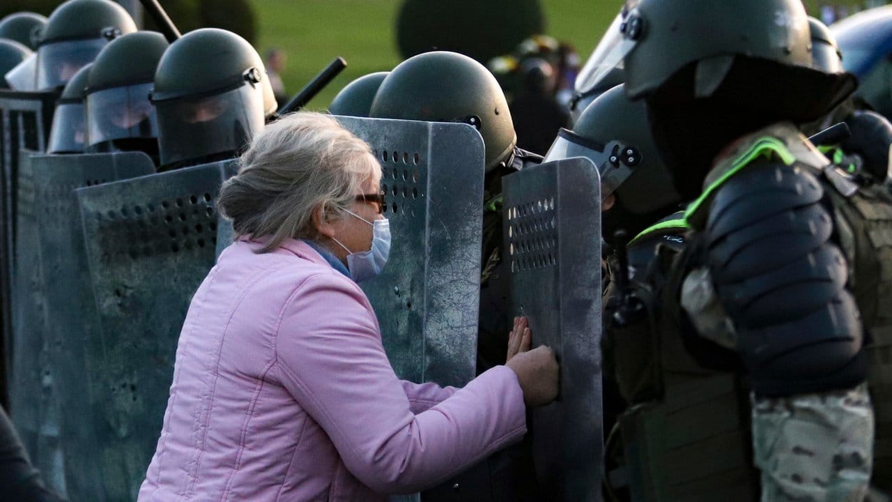 Eine Frau drückt gegen ein Schild eines Polizisten während einer Kundgebung in Minsk.