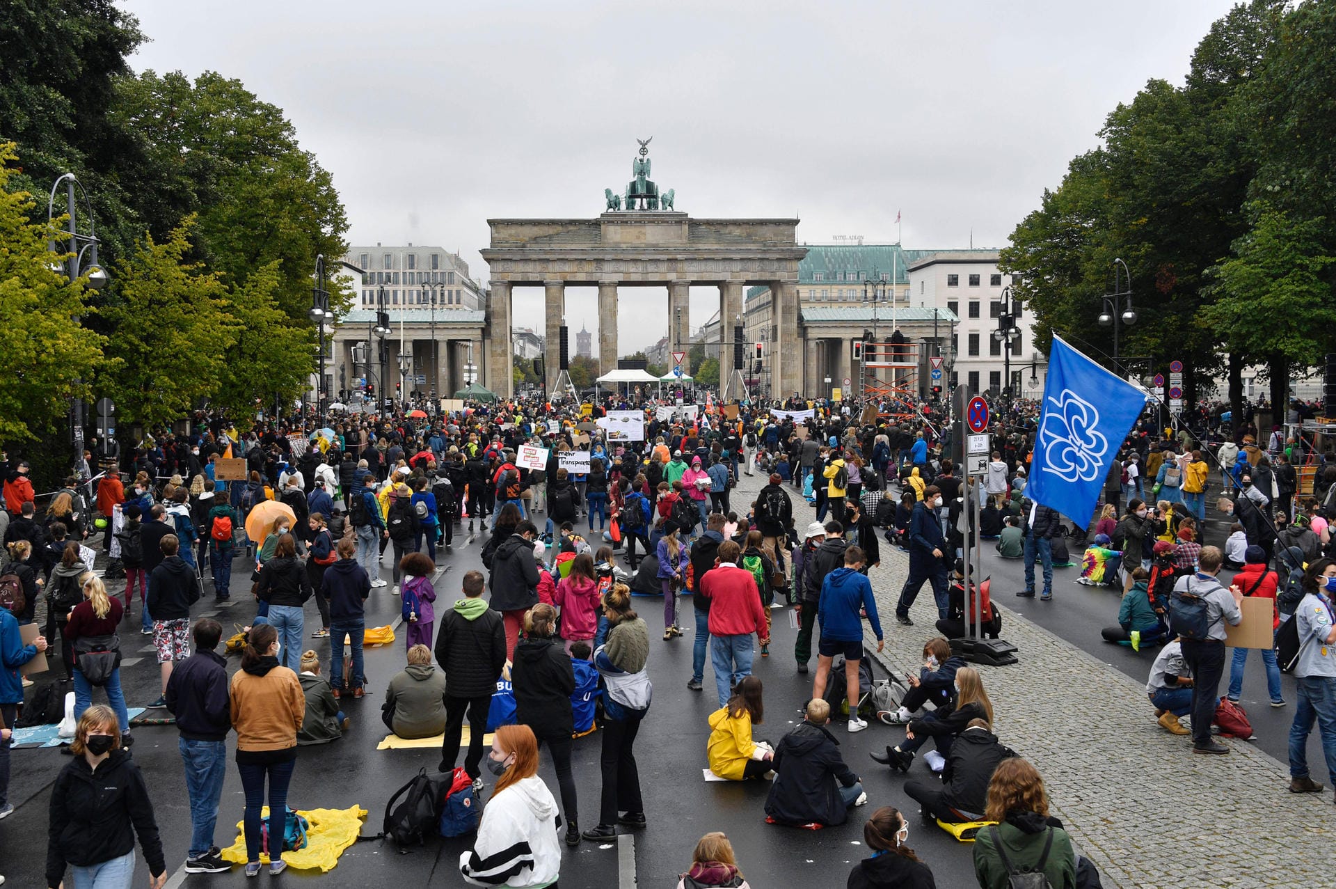 Berlin: Protestierende sitzen vor dem Brandenburger Tor am Boden. Zuvor wurden auf dem Asphalt Punkte markiert, auf denen sich die Teilnehmenden niederlassen sollten, um den Abstand einzuhalten.