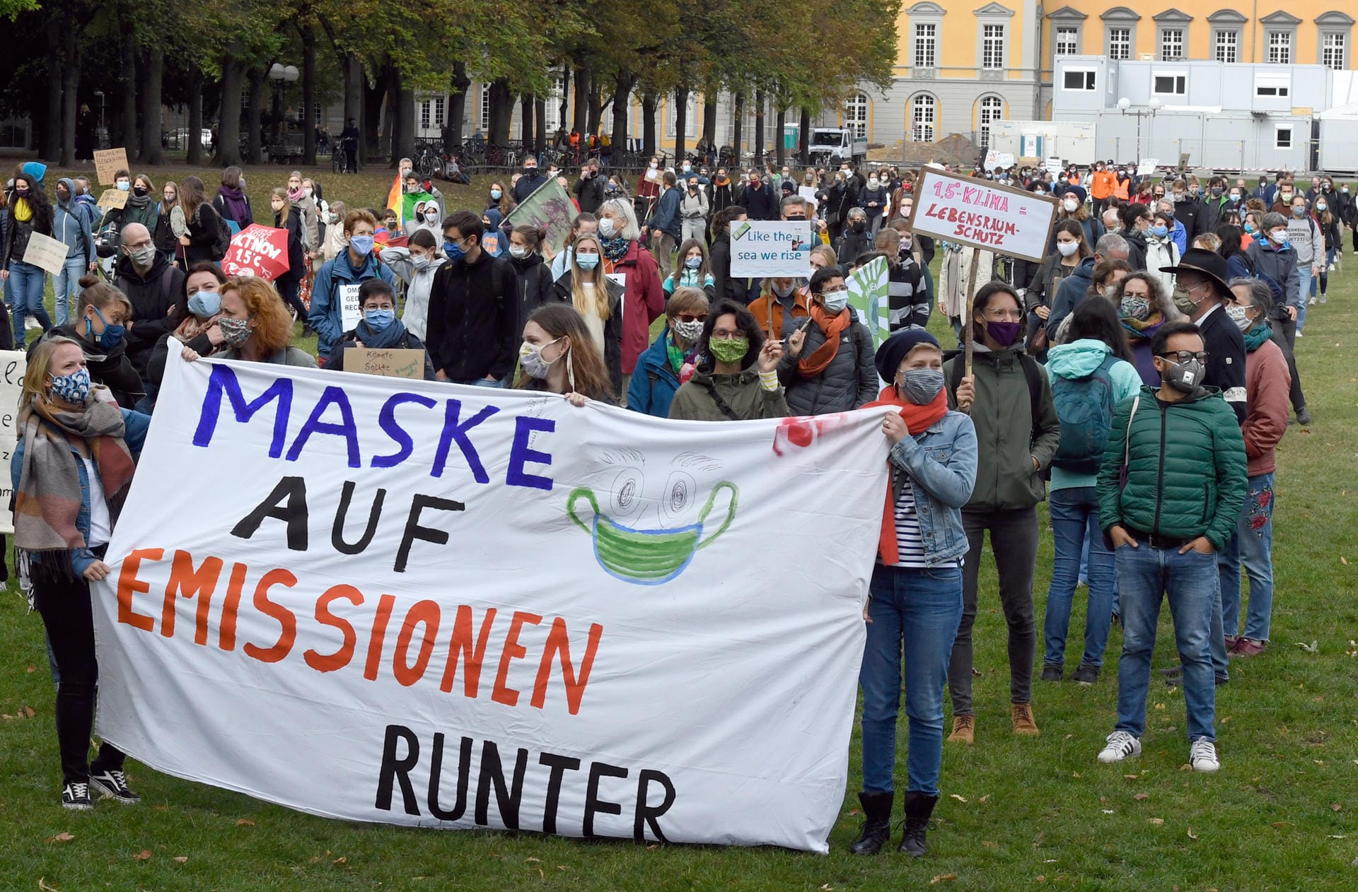Bonn: Ein Banner mit der Aufschrift "Maske auf Emissionen runter" für bessere Klimagesetze wird in die Höhe gehalten. Nach Veranstalterangaben versammelten sich dort 3.000 Menschen.