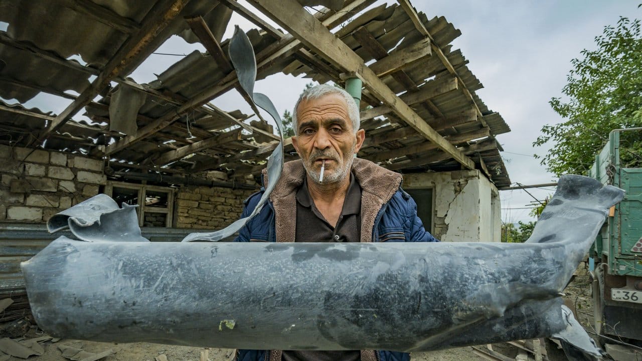 Ein Mann zeigt die Reste einer Rakete, die sein Haus im armenischen Martuni zerstört hat.