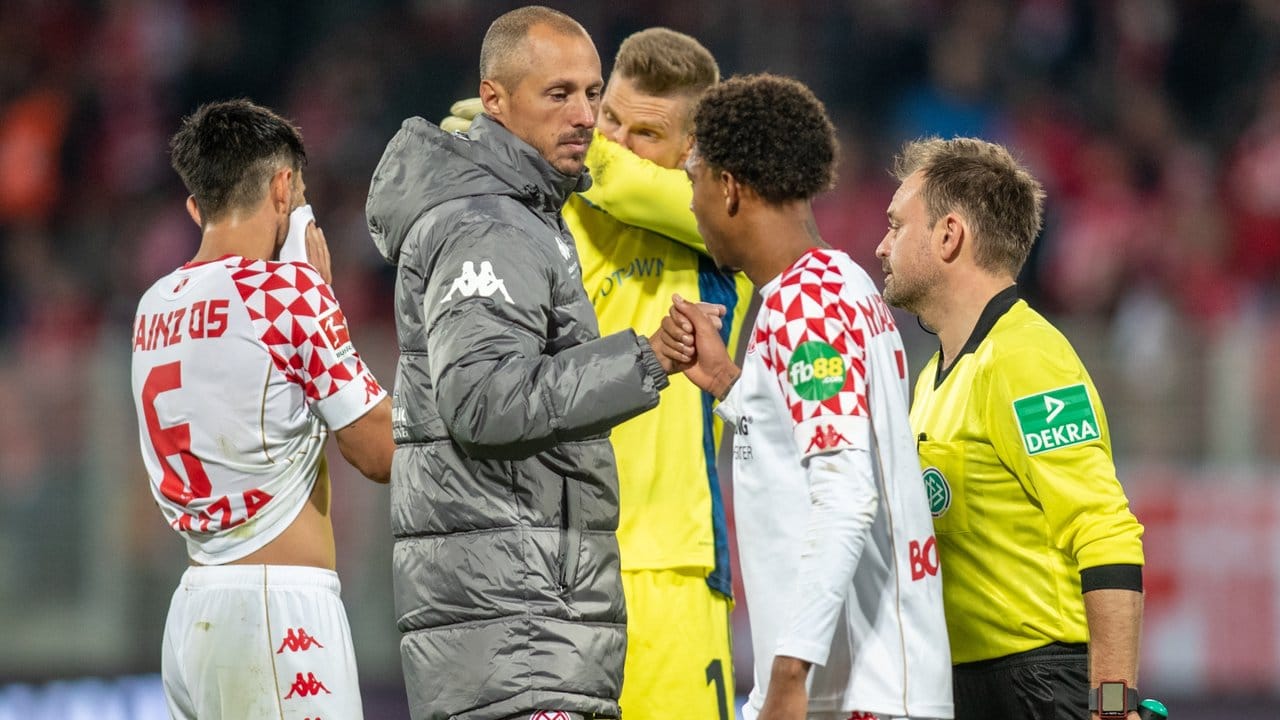 Nach der Niederlage klatscht der Mainzer Interimstrainer Jan-Moritz Lichte (M) mit den Spielern ab. Nach der Niederlage klatscht der Mainzer Interimstrainer Jan-Moritz Lichte (M) mit den Spielern ab.