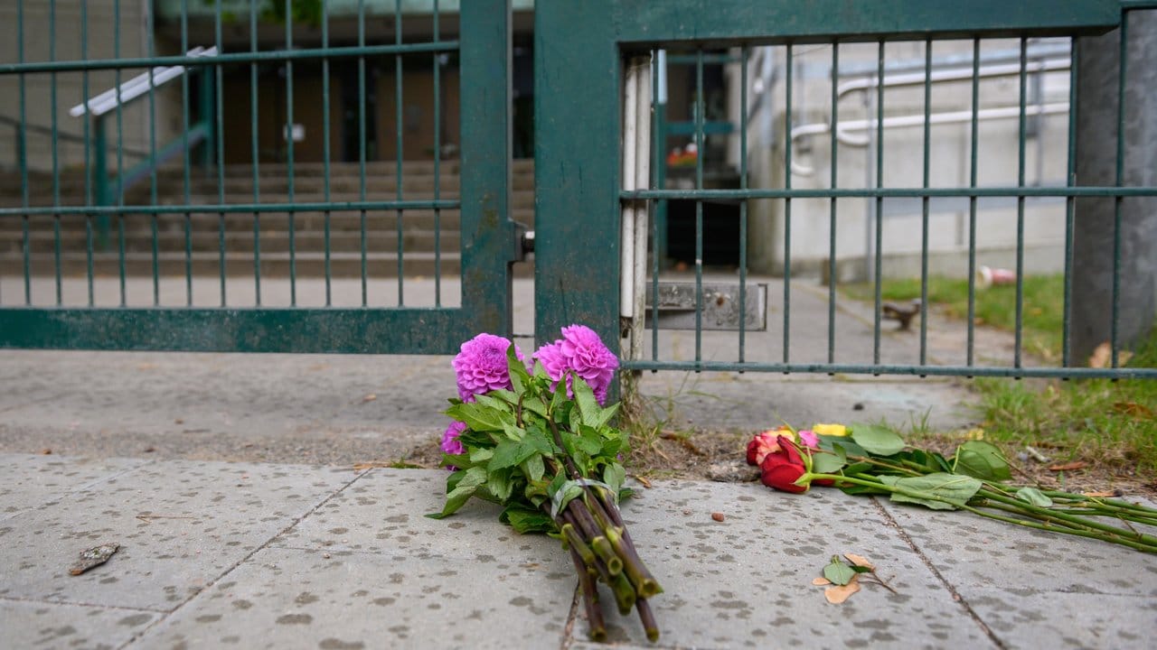 Passanten haben Blumen vor dem Eingangsbereich der Hamburger Synagoge abgelegt.