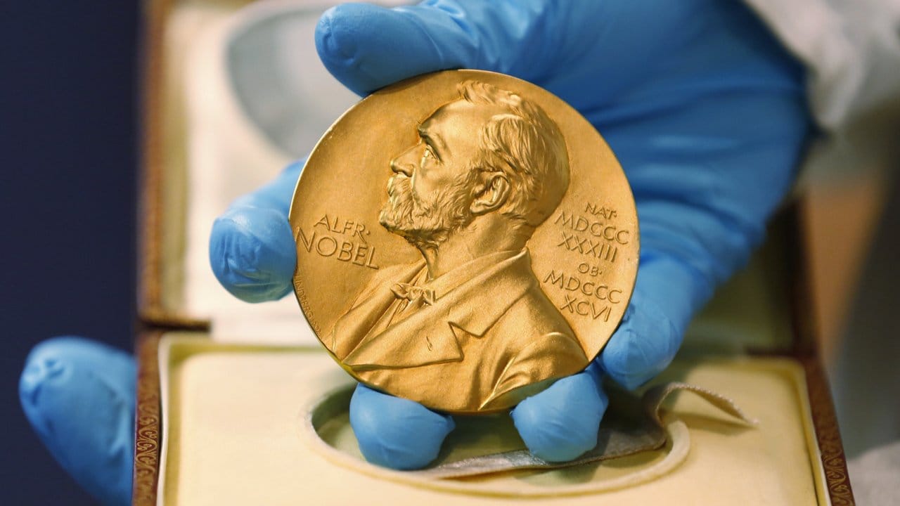 Ein Mitarbeiter der Nationalbibliothek zeigt eine goldene Nobelpreismedaille. Ein Mitarbeiter der Nationalbibliothek zeigt eine goldene Nobelpreismedaille.