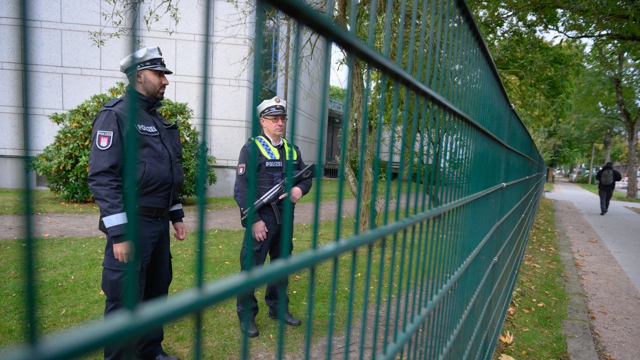 Polizisten stehen am Tag nach der Attacke auf dem Gelände der Hamburger Synagoge und halten Wache.