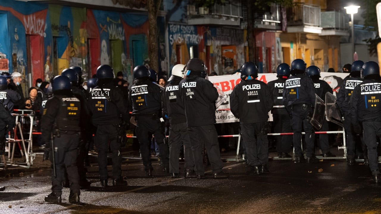 Polizisten stehen vor Demonstranten, die gegen die Räumung des besetzten Hauses "Liebig 34" protestieren.