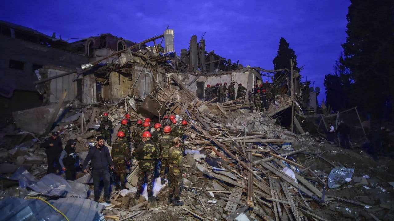 Aserbaidschanische Soldaten und Rettungskräfte der Feuerwehr suchen nach Überlebenden in einem Wohngebiet nach dem Raketenbeschuss durch armenische Streitkräfte.