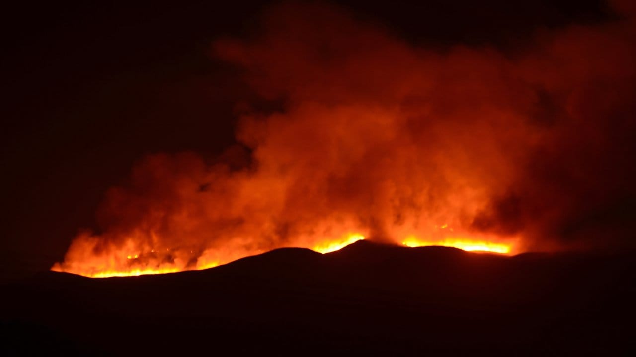 Hell scheinen die Falmmen eines Feuers auf dem Kilimandscharo.