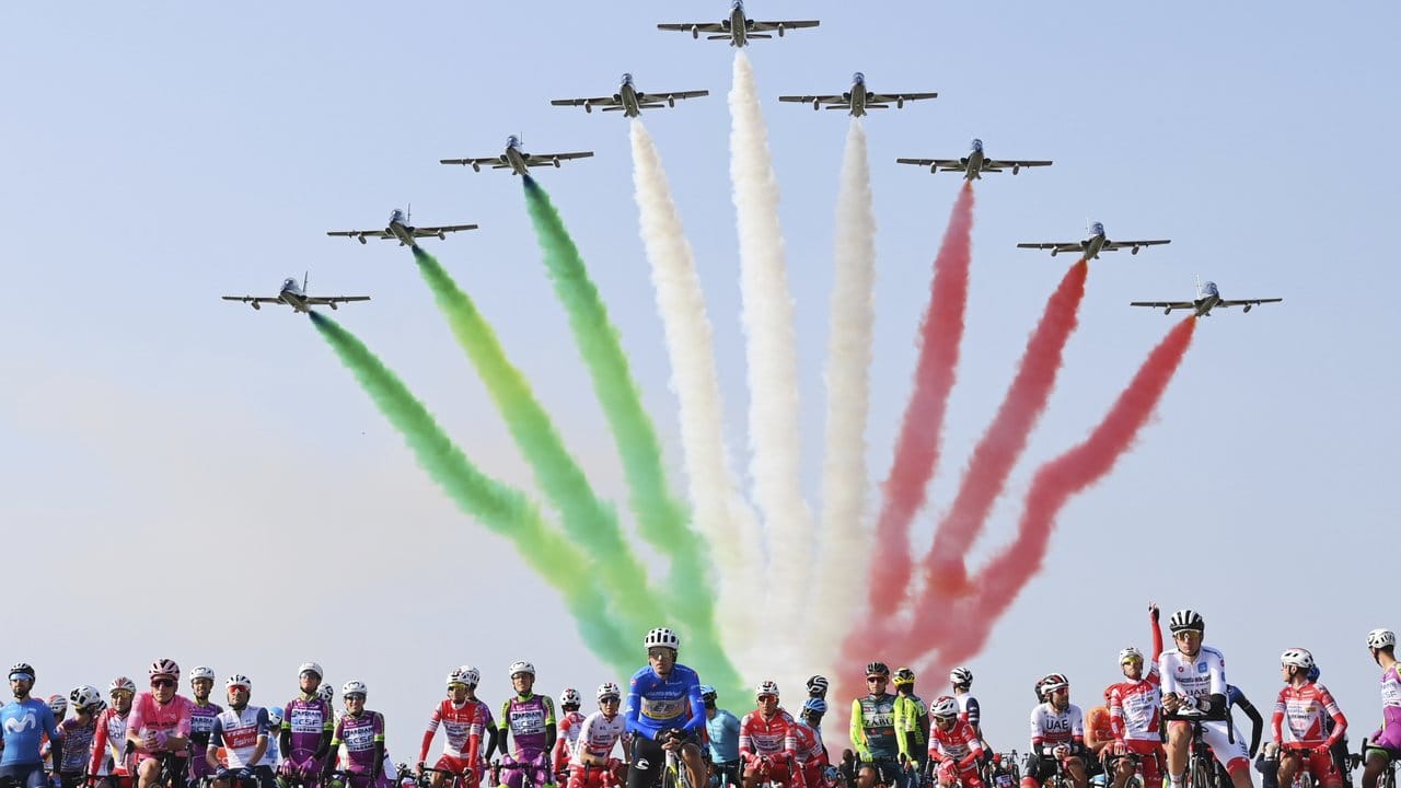 Eine Kunstflugstaffel der italienischen Luftwaffe fliegt über das Fahrerfeld hinweg. Eine Kunstflugstaffel der italienischen Luftwaffe fliegt über das Fahrerfeld hinweg.