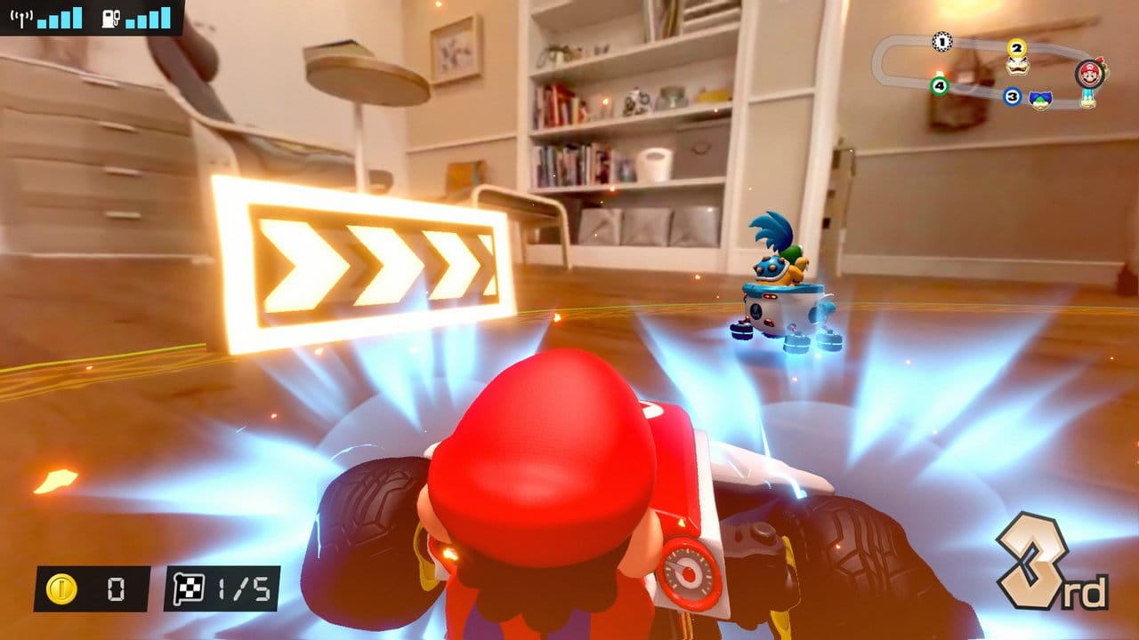 Held in zwei Welten: Der digitale Super-Mario rast im realen ferngesteuerten Spielzeug-Kart durch die Wohnung.