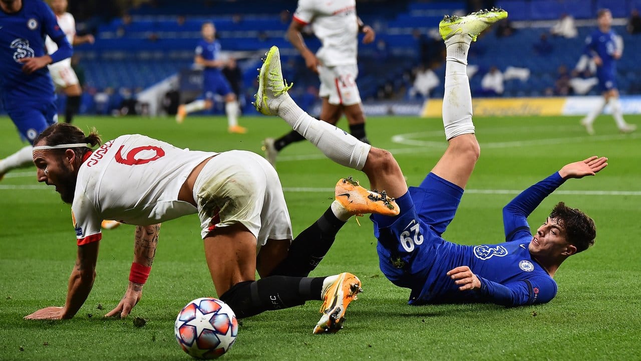 Chelseas Kai Havertz (r) liegt nach einem Zweikampf mit Nemanja Gudelj vom FC Sevilla am Boden.