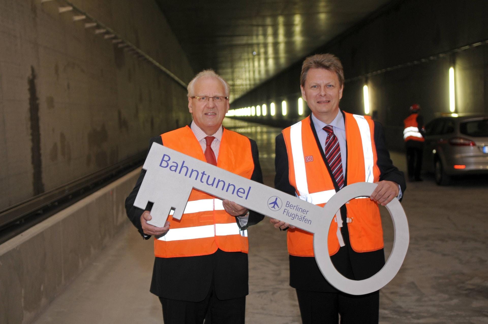 Zumindest der Tunnel für die unterirdische Anbindung ans Bahn-Netz ist im Juni 2010 schon fertig. Hier wird der symbolische Schlüssel für den Rohbau vom BBI-Geschäftsführer Betrieb, Manfred Körtgen, an Ralph-Peter Hänisch von der DB Netz AG übergeben.