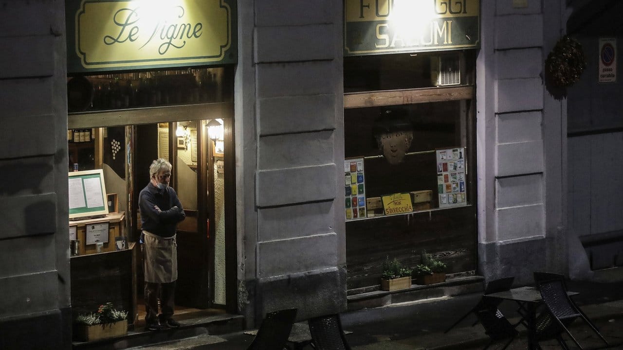 Kaum Gäste am Abend: Der Besitzer eines Restaurants in Rom schaut auf die Straße.