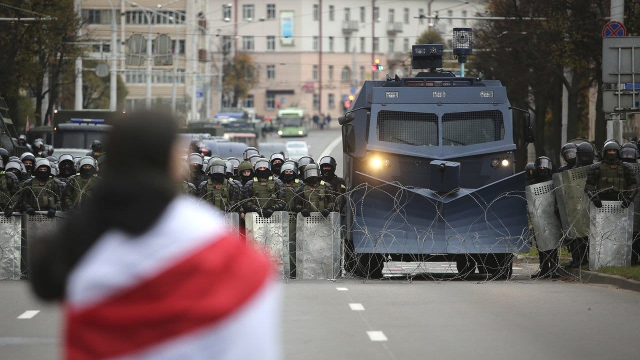 Ein Demonstrant steht in Minsk einer Reihe von Polizisten gegenüber.