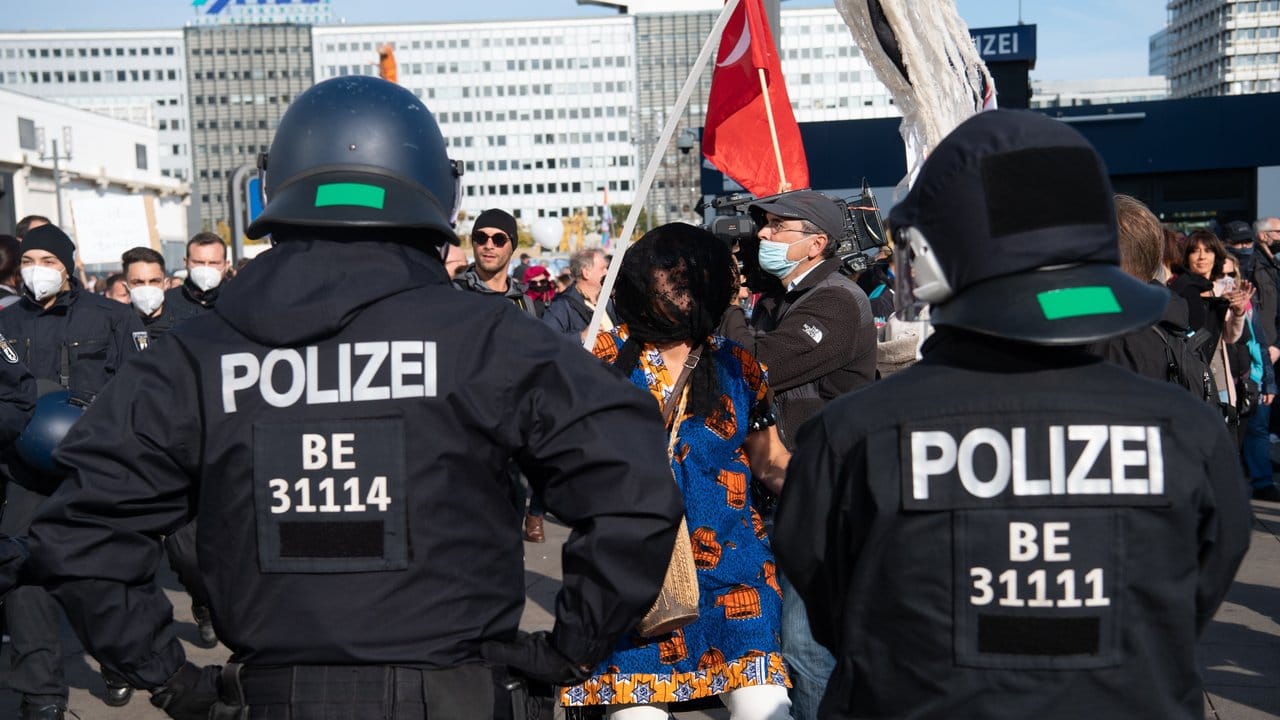 Polizisten beobachten am Alexanderplatz in Berlin eine Demonstration gegen die Corona-Auflagen.