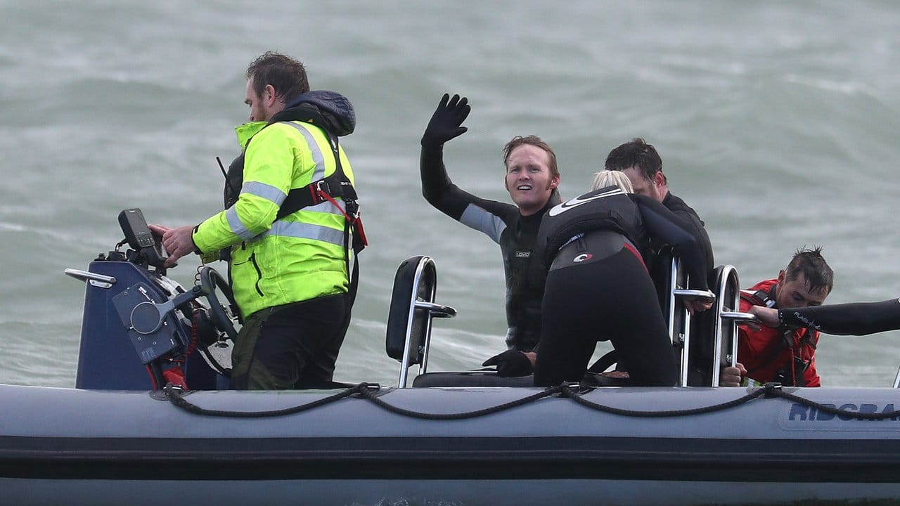 John Bream, ehemaliger Fallschirmspringer aus Großbritannien, winkt aus einem Boot, das ihn nach seinem Sprung aus etwa 40 Metern Höhe ins Meer geborgen hat.