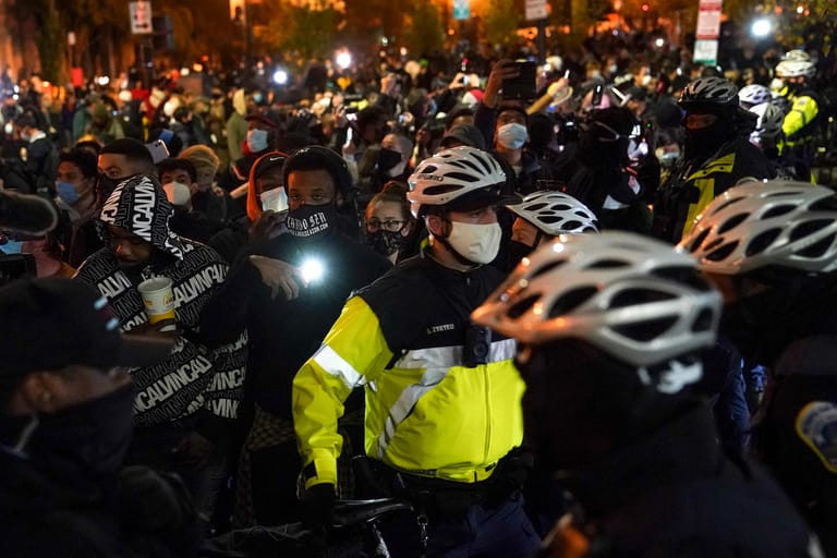 USA, Washington: Die Metropolitan Police patrouilliert am Tag der US-Präsidentschaftswahl, während Demonstranten durch die Straßen in der Nähe des Weißen Hauses ziehen.