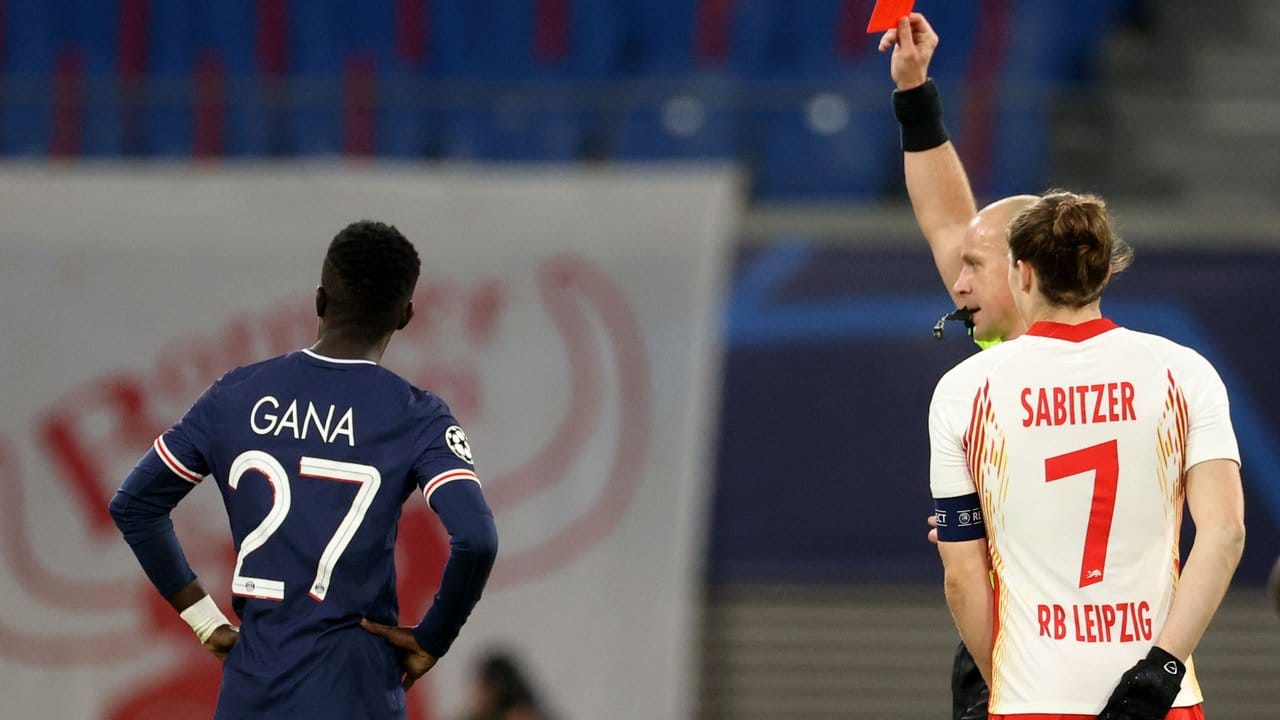 Idrissa Gana Gueye (l) von PSG bekommt die Rote Karte von Schiedsrichter Szymon Marciniak (M, neben Marcel Sabitzer/7). Idrissa Gana Gueye (l) von PSG bekommt die Rote Karte von Schiedsrichter Szymon Marciniak (M, neben Marcel Sabitzer/7).