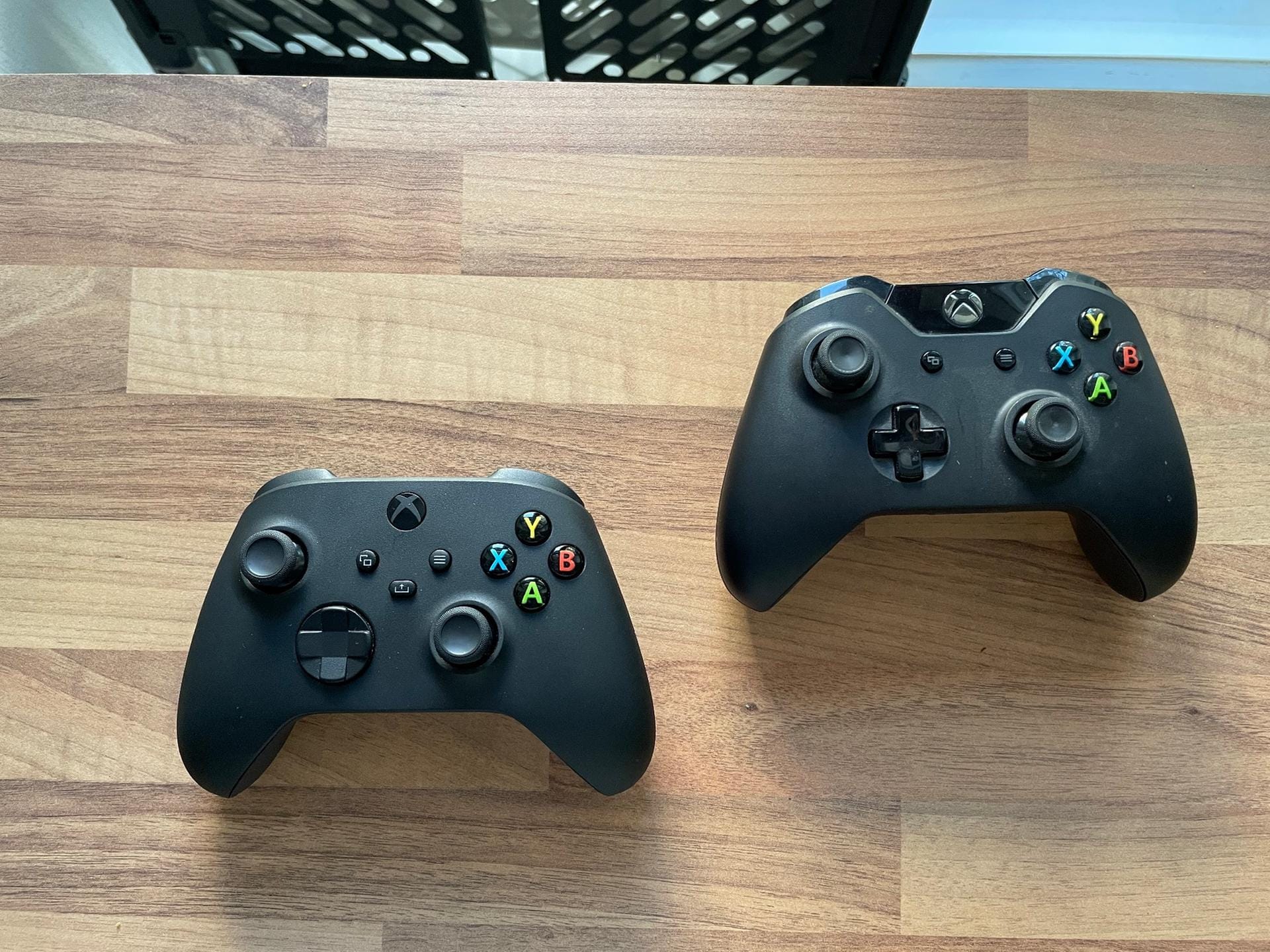 Hier der neue Controller (vorne links) und der der Xbox One im direkten Vergleich. Gut zu erkennen sind beim alten Controller die glänzenden Oberflächen. Sie sind beim neuen Modell entfallen. Insgesamt fasst sich der Neue gut an und ist dabei absolut vertraut.