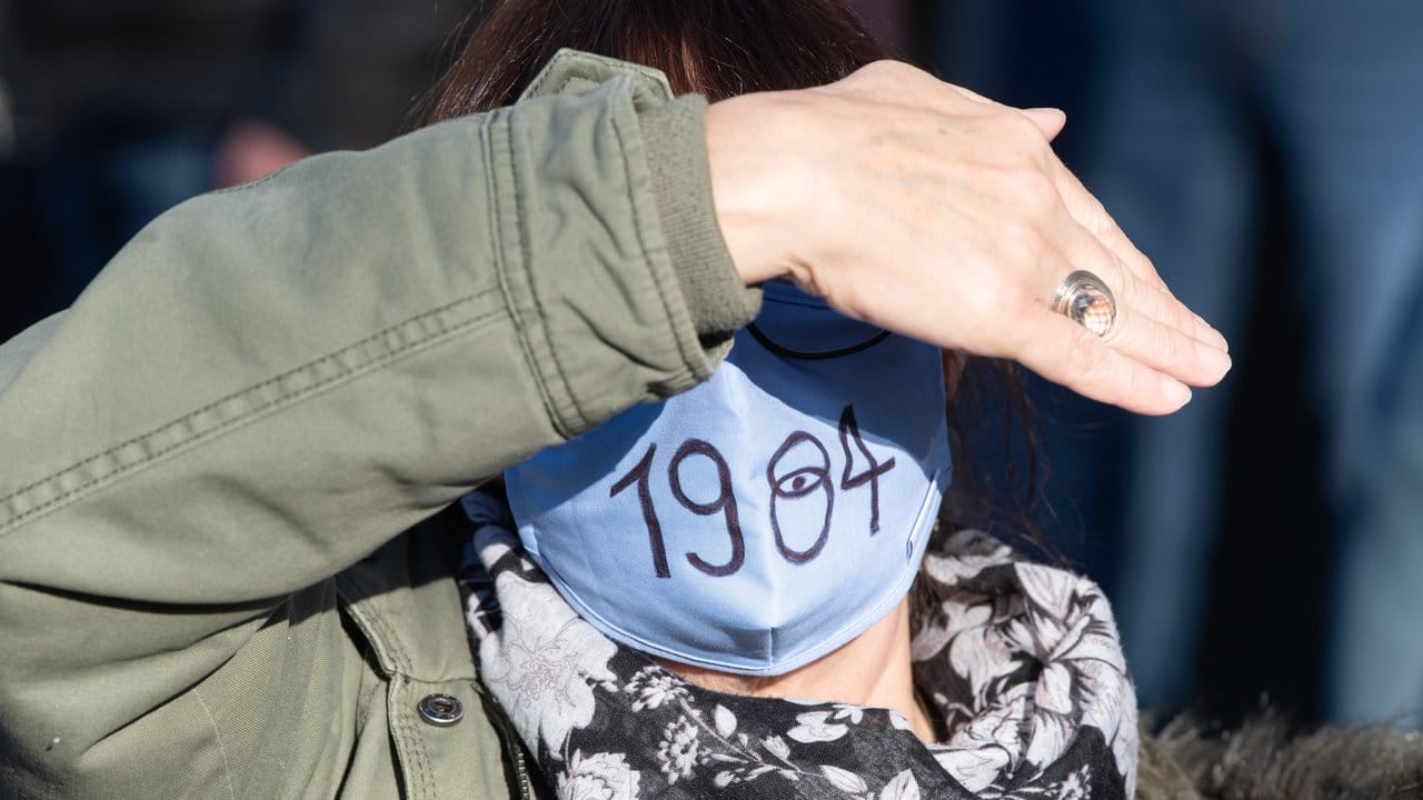 Eine Demo-Teilnehmerin trägt einen Mund-Nasen-Schutz mit der Aufschrift "1984" - in Anspielung auf den berühmten Roman von George Orwell.