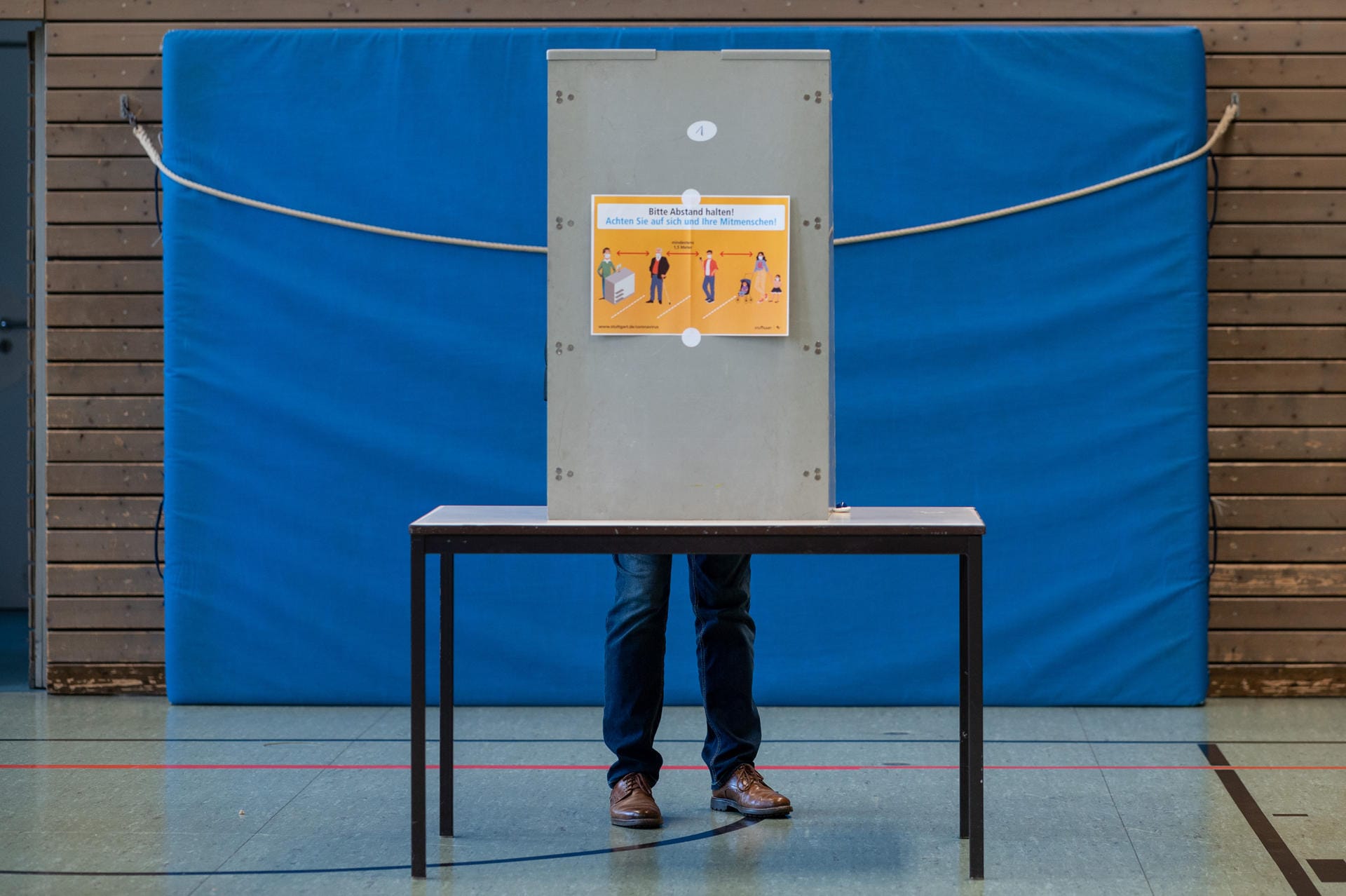 Ein Mann gibt seine Stimme in der Wahlbox ab: Das Wahllokal wurde in eine Sporthalle verlegt.