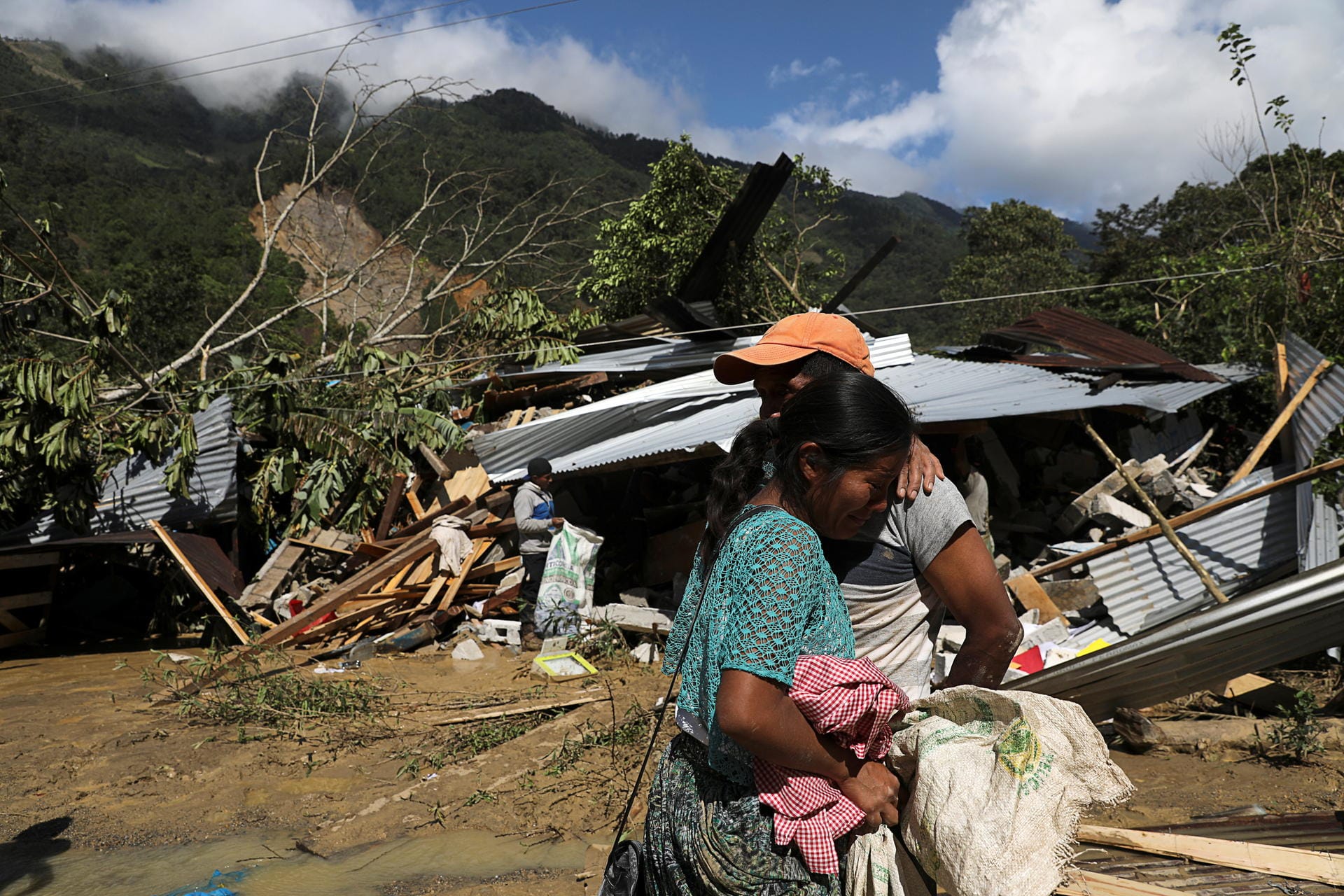 Guatemala: Ein Vater und seine Tochter stehen vor den Trümmern ihres Hauses. Dort werden noch mindestens 103 Menschen vermisst.