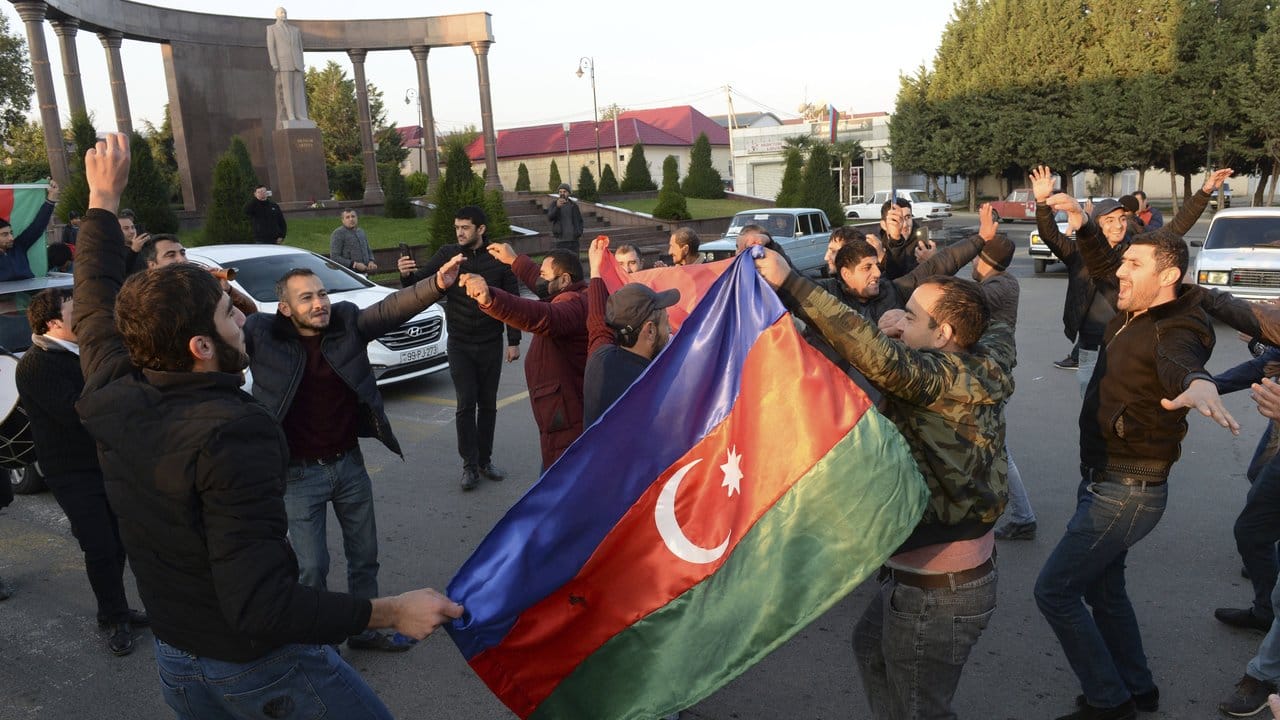 Menschen feiern in Ganja und halten aserbaidschanische Nationalflaggen.