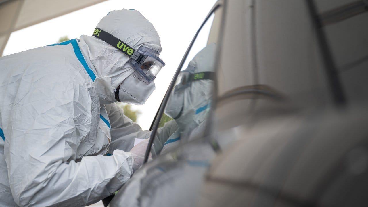Ein Mitarbeiter der Corona-Abstrichstelle Heilbronn führt einen Coronatest durch. Ein Mitarbeiter der Corona-Abstrichstelle Heilbronn führt einen Coronatest durch.