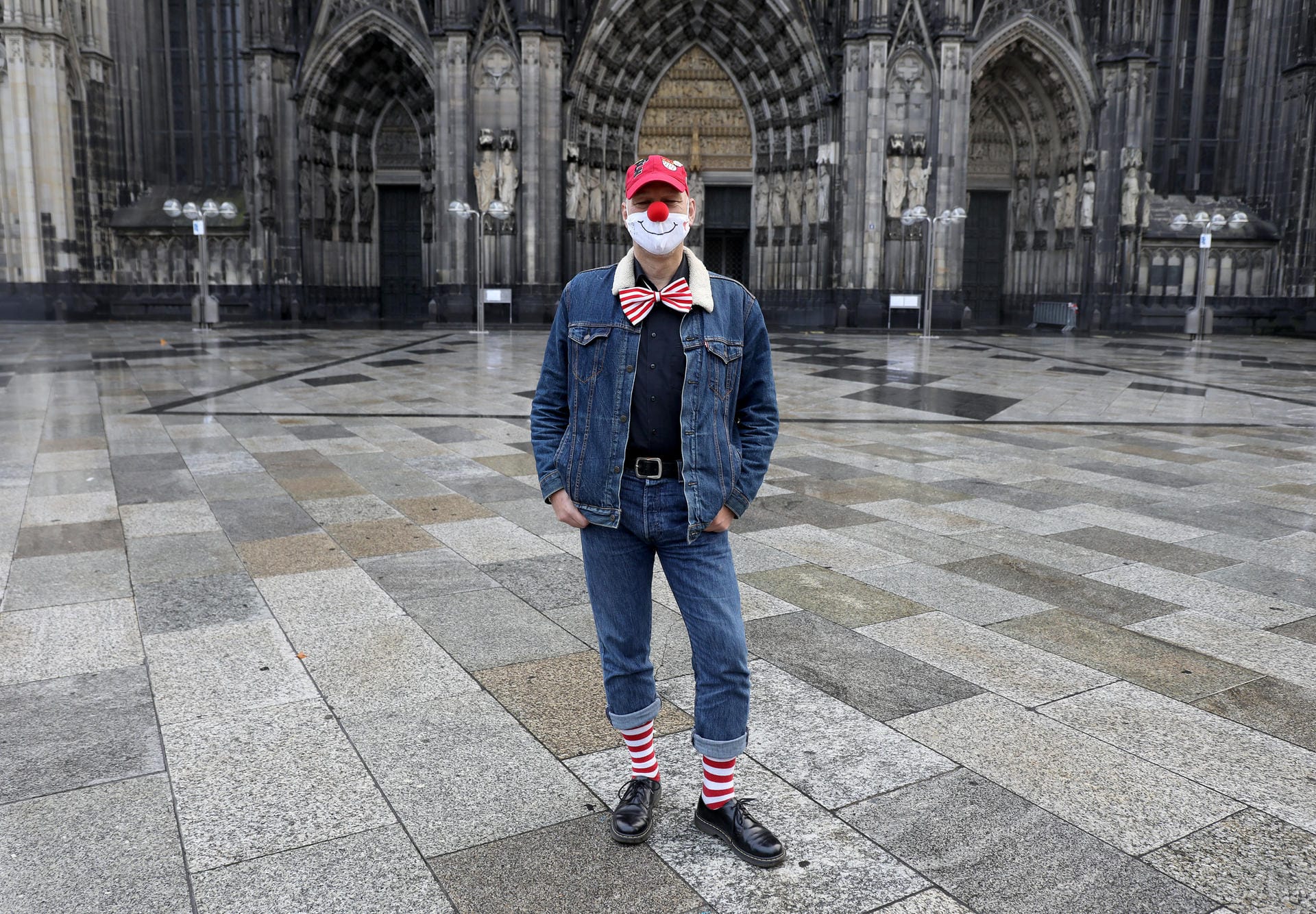 Der Karnevalist Ingo Schönfeld steht in Verkleidung vor dem Dom: Schönfeld ist trotz Absage des Karnevalsauftakts verkleidet zu seiner Arbeitsstätte nach Köln gekommen.