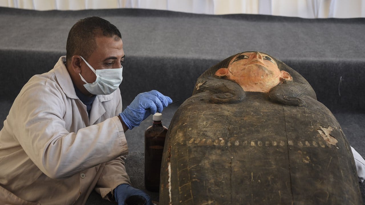 Ein ägyptischer Archäologe restauriert während einer Pressekonferenz eine neu entdeckte antike Statue.