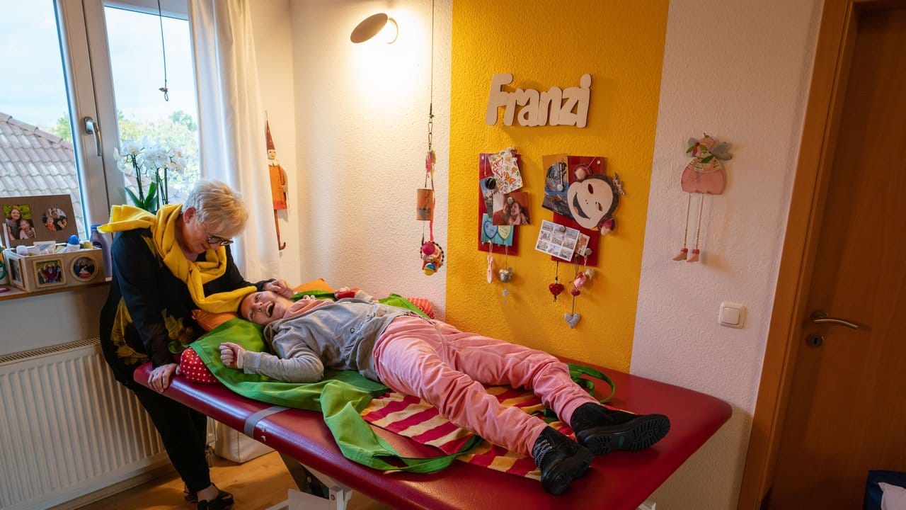 Margret Pohl, Kinderärztin und Vorsitzende des Vereins für Körper- und Mehrfachbehinderte Mainz, steht in ihrem Wohnhaus an der Liege, auf der ihre Tochter Ella Franziska liegt.