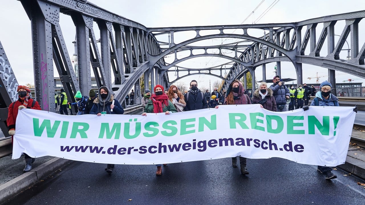 Teilnehmer einer Demonstration, die als "Schweigemarsch" bezeichnet wird und sich gegen die Corona-Politik der Bundesregierung richtet, auf der Bornholmer Brücke.