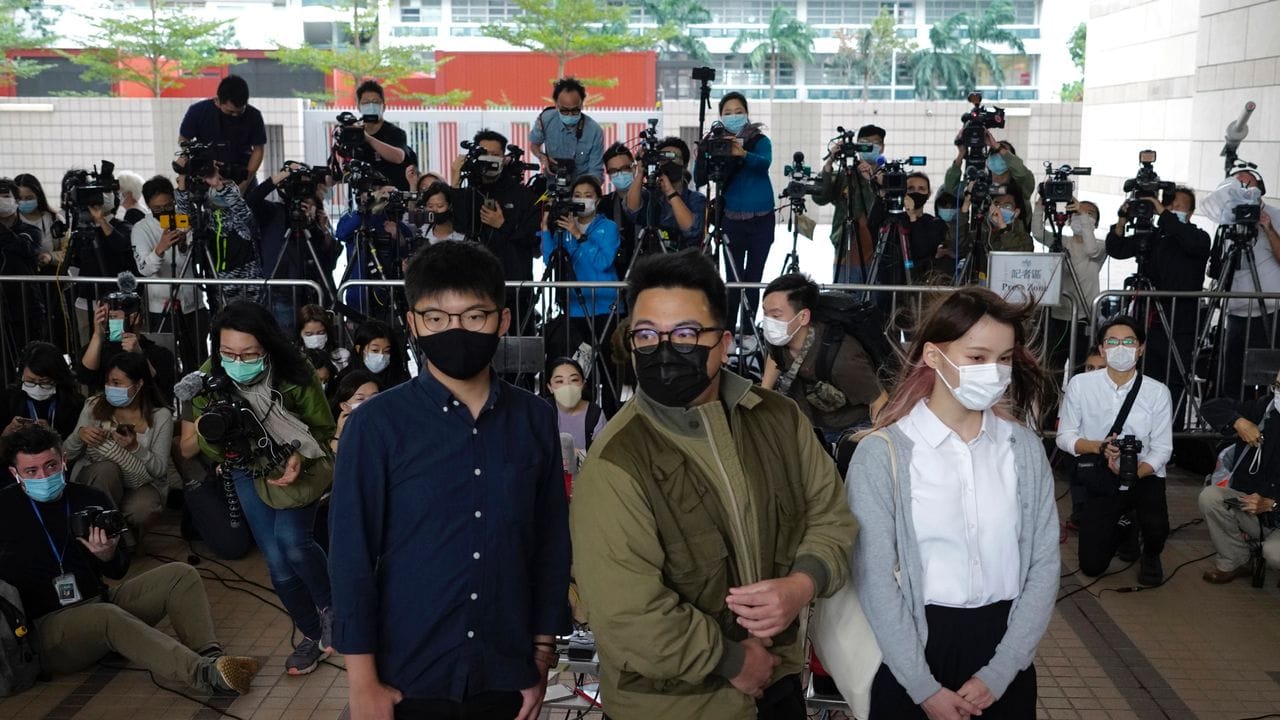 Die Aktivisten Joshua Wong (l-r), Ivan Lam und Agnes Chow stehen vor dem Gerichtsgebäude in Hongkong.