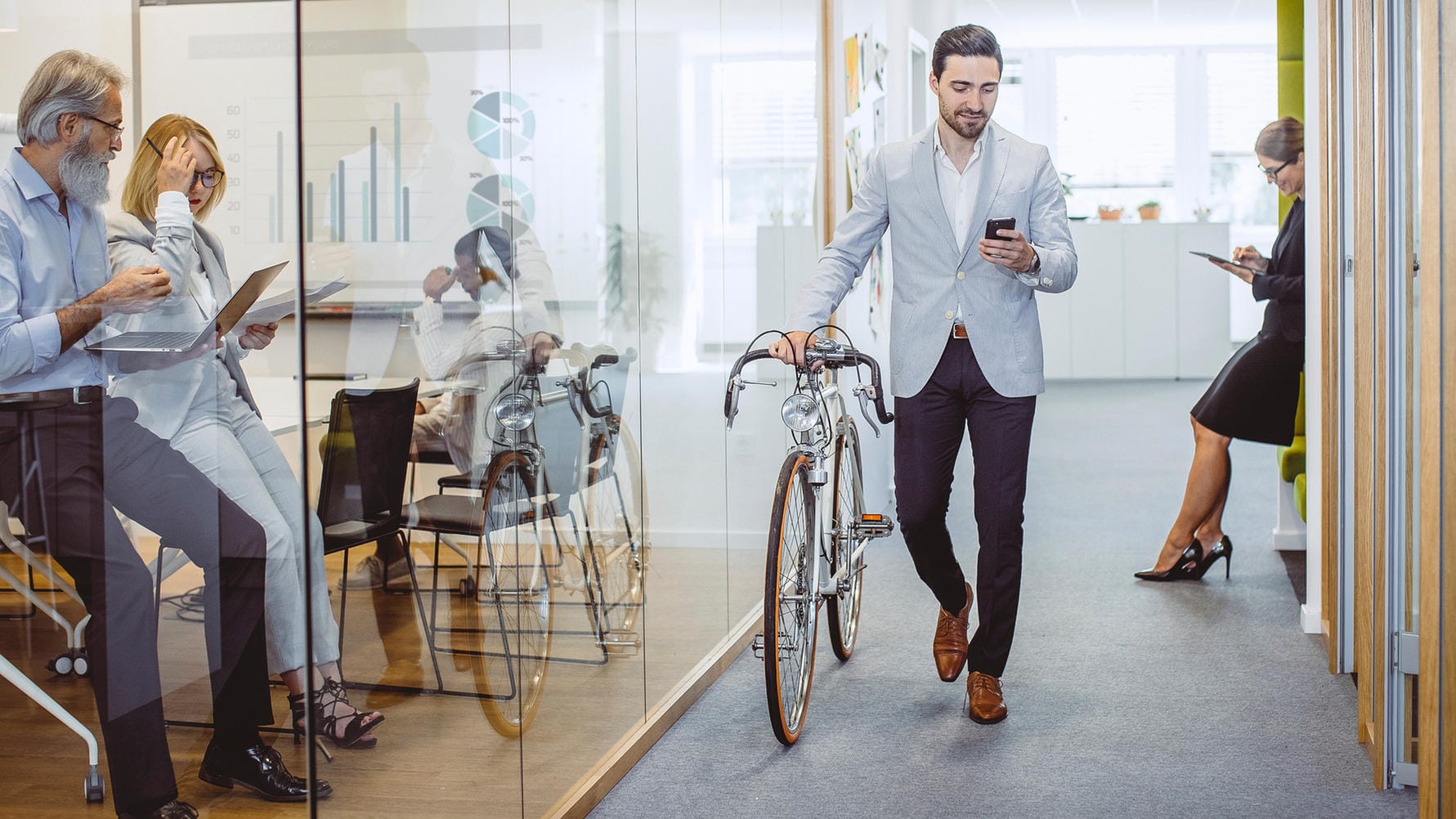 Ein Mann verlässt das Büro mit seinem Fahrrad (Symbolbild): Wer Teilzeit arbeitet, hat früher Feierabend – und Zeit für andere Dinge im Leben.