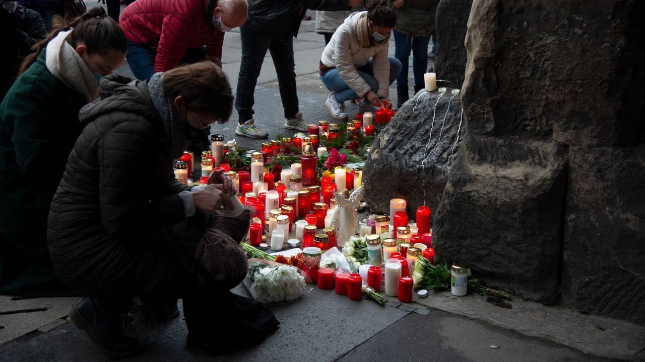 Trauernde legen am Morgen nach der Amokfahrt mit fünf Toten in Trier an der Porta Nigra Kerzen und Blumen nieder.