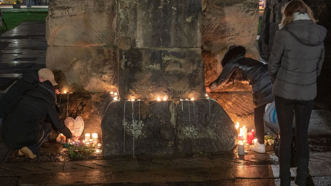 Menschen zünden an der Porta Nigra in Trier Kerzen für die Opfer der Amokfahrt an.