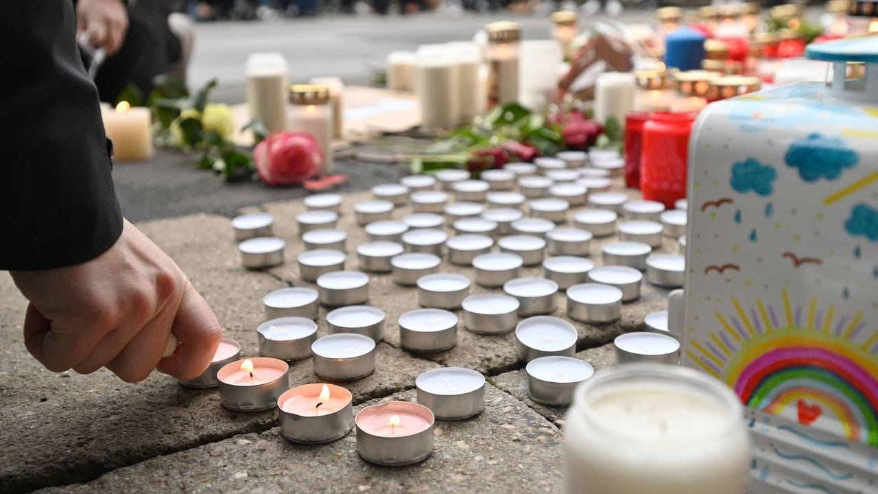 Trauernde zünden nach der Amokfahrt mit fünf Toten in Trier an der Porta Nigra Kerzen an.