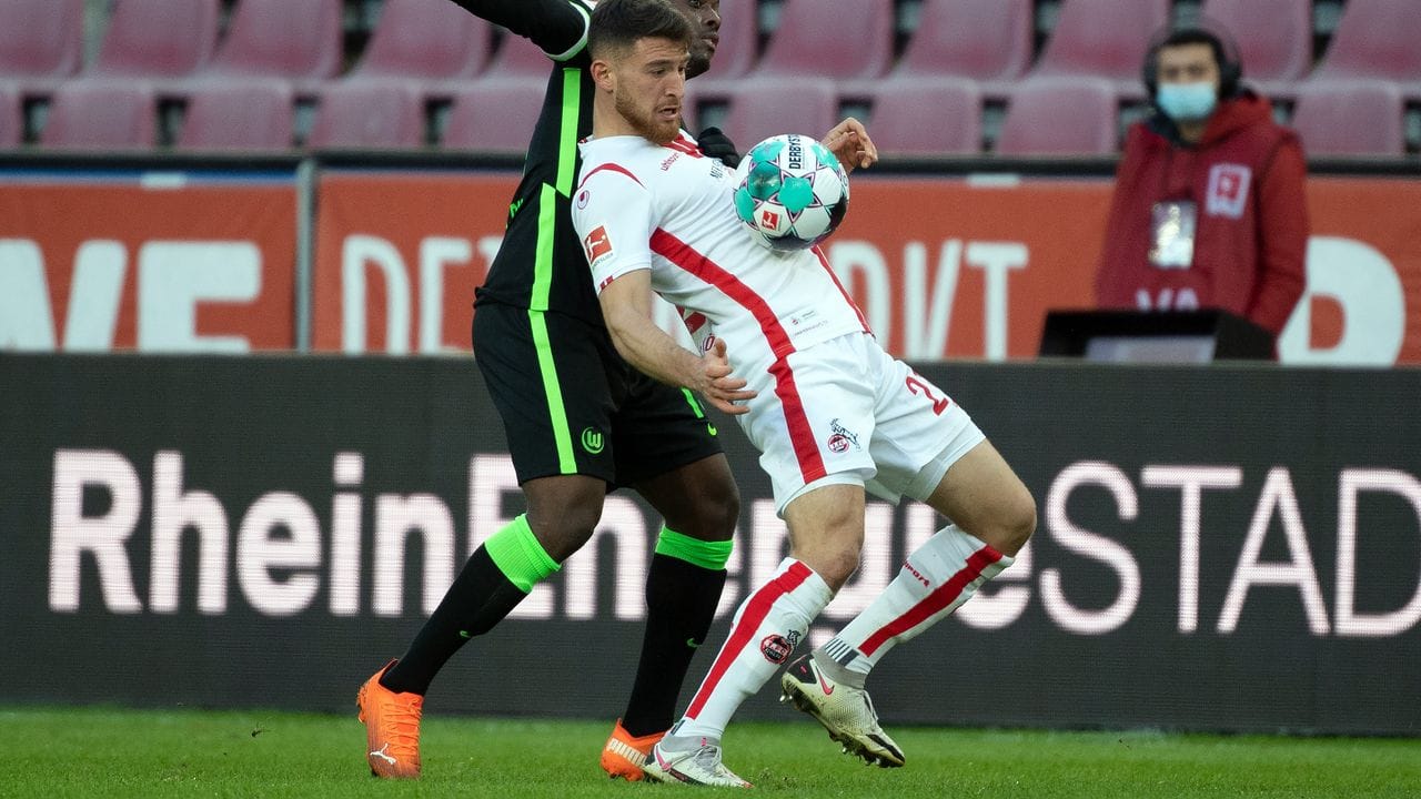 Kölns Salih Özcan (r) schirmt das Spielgerät geschickt mit dem Körper vor dem Wolfsburger Jerome Roussillon ab.