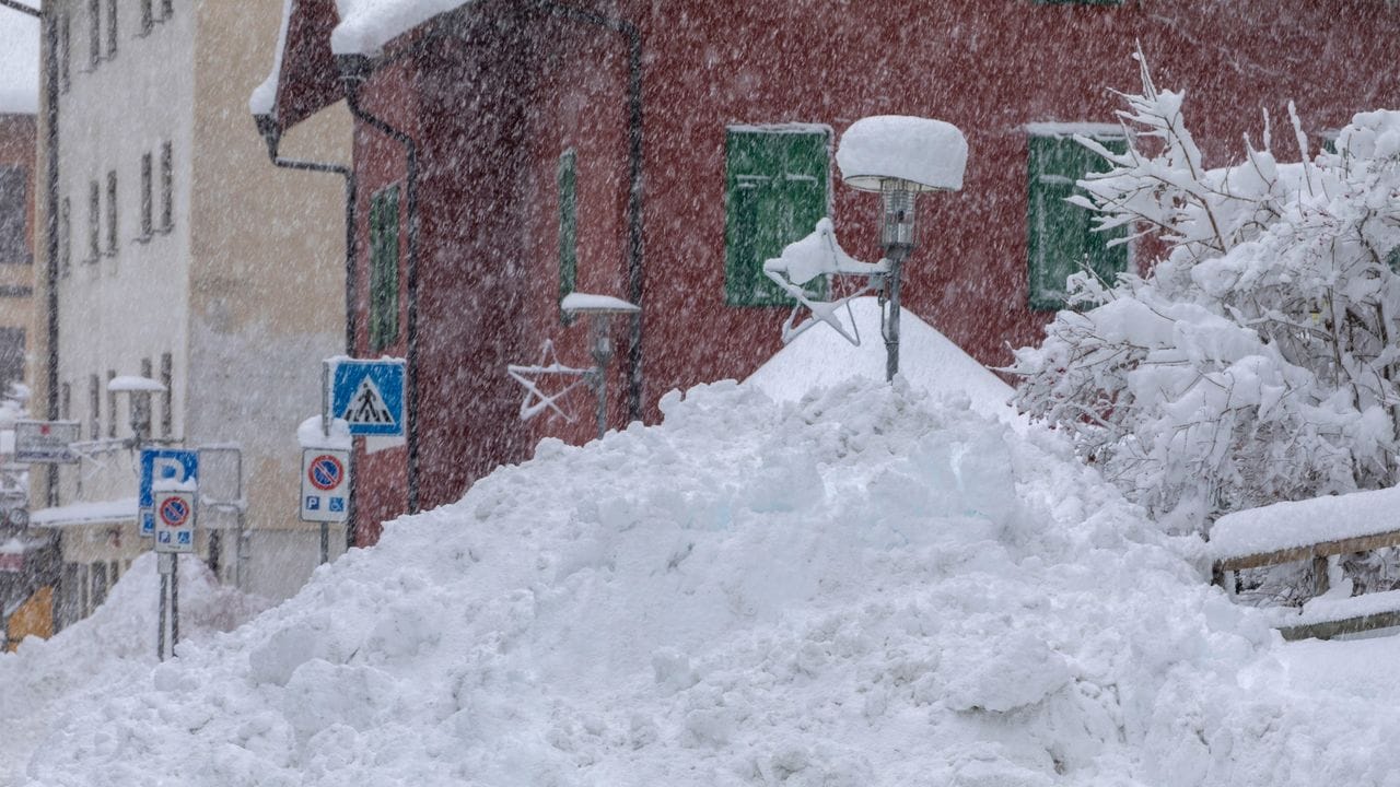 Schnee liegt hoch aufgetürmt am Straßenrand in der Gemeinde Brenner in Südtirol.