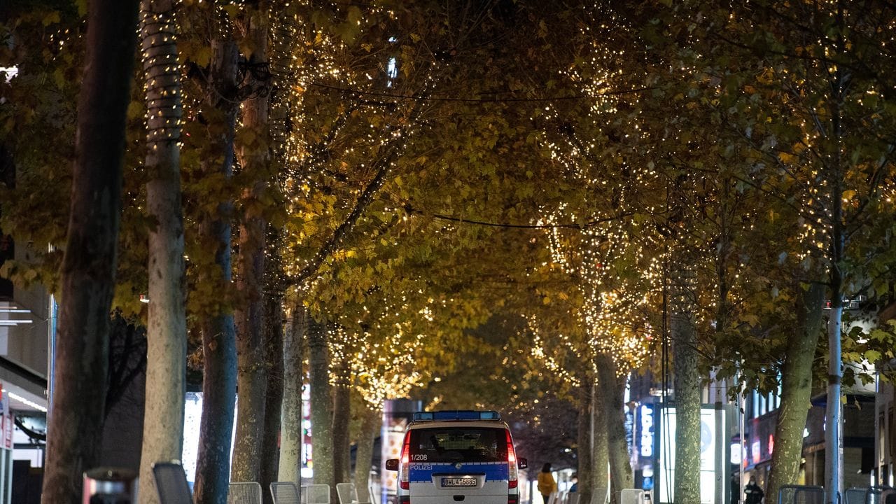 Ein Polizeiauto fährt durch die leere Innenstadt von Stuttgart. Ein Polizeiauto fährt durch die leere Innenstadt von Stuttgart.