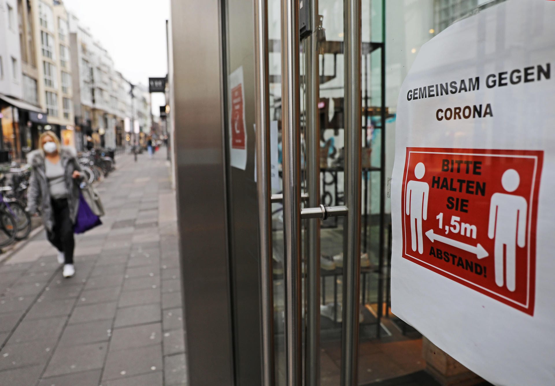 Ein Schild mit der Aufschrift "Gemeinsam gegen Corona" hängt im Eingang eines Geschäftes in einer Einkaufsstraße (Ehrenstraße): Der Lockdown soll die Ausbreitung des Virus verlangsamen.