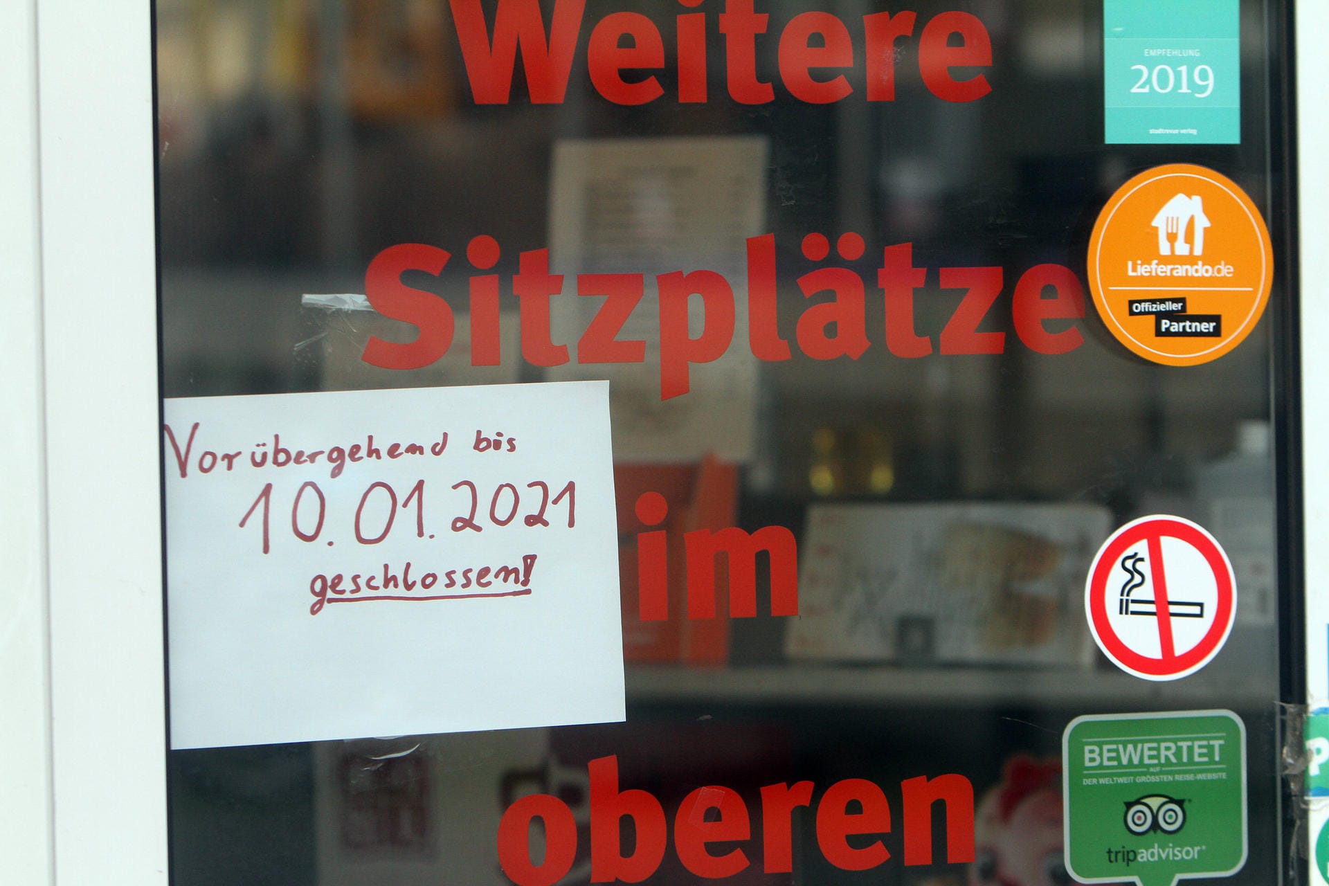 Ein Schild mit Aufschrift vorübergehend bis 10.01.2021 geschlossen klebt in der Eiingangstür zu einem Restaurant in der Innenstadt von Köln.