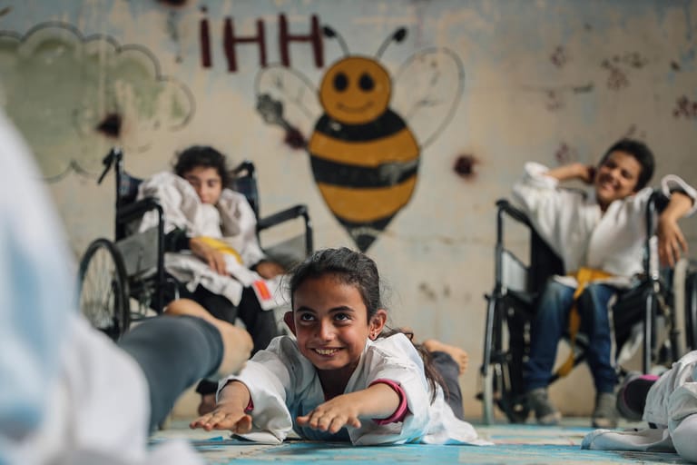 Für den syrischen Fotografen Anas Alkharboutli findet die Jury eine ehrenvolle Erwähnung. Auf seinem Bild zeigt er eine Schule nahe Aleppo, in der Mädchen und Jungen, mit und ohne Behinderung, zusammen unterrichtet werden. Obwohl die Kinder in einem Alter zwischen sechs und 15 einige Jahre trennen, vereint sie eines: sie alle haben Kriegserfahrungen zu verarbeiten.